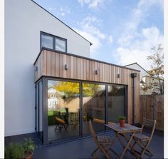 an outdoor patio with table and chairs next to the house's sliding glass doors