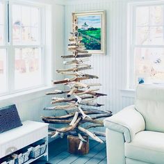 a christmas tree made out of driftwood in a living room next to a window