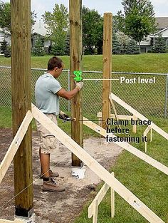 a man is working on some wooden posts