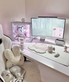 a cat laying on a chair in front of a computer desk with a monitor and keyboard