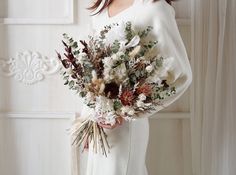 a woman holding a bouquet of flowers in her hands