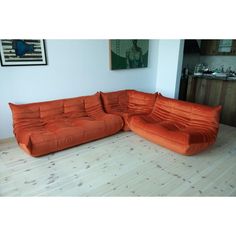 an orange couch sitting on top of a hard wood floor