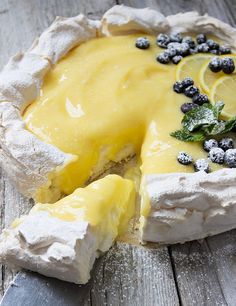 a lemon and blueberry cheesecake on a wooden table