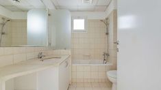 a bathroom with a sink, toilet and bathtub next to a mirror on the wall