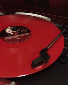 a red record player sitting on top of a table