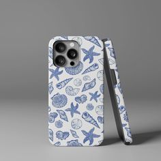 an iphone case with blue and white sea animals on it, in front of a gray background