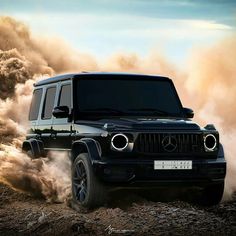 a black jeep driving through dirt with dust coming out of the front and behind it