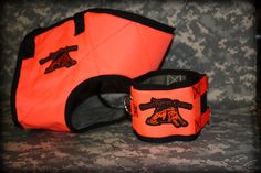 two orange and black dog collars sitting next to each other on a camouflage background