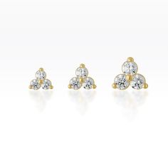 three diamond stud earrings in yellow gold, set with four diamonds on each earring