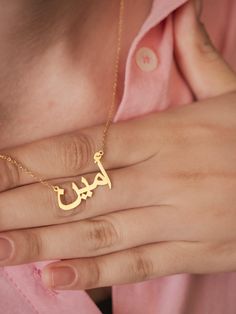 This personalized 14K gold Arabic name necklace promises to become a cherished symbol of your heritage and elegance. Imagine the grace and sophistication it will add to your look as you adorn your neck with this exquisite piece. Crafted with meticulous attention to detail, this necklace will become a timeless treasure, reflecting the beauty of the Arabic language and culture. The intricate calligraphy of your name will create a truly personalized and meaningful piece that will be admired for gen