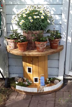 a potted planter on top of a wooden table with flowers in it and plants growing out of the holes