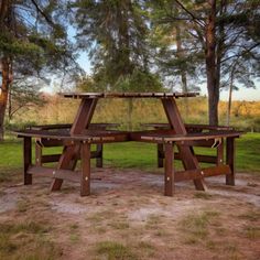 two picnic tables in the middle of a field