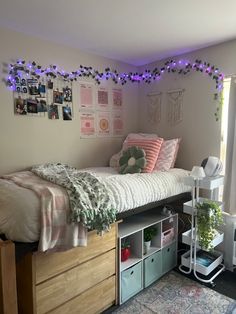 a bedroom with a bed, desk and storage drawers under the bedspread is lit by purple lights