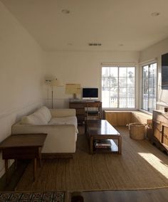 a living room filled with furniture and a flat screen tv on top of a wooden dresser