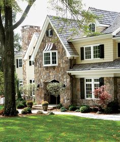 a stone house with white trim and black shutters