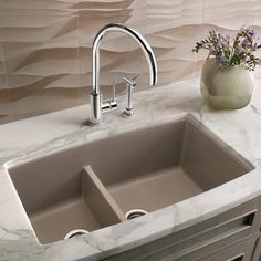 a kitchen sink sitting under a faucet on top of a marble countertop