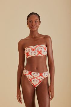 Embrace the vibrancy of summer with the FARM Rio Summer Beach Bikini Bottom. Its vivacious red and white pattern draws inspiration from tropical havens, making every moment feel like a sunny escape. The flattering high-leg cut and comfortable mid-rise waist complement your natural silhouette, while the playful tie-back detail on the coordinating top adds a touch of whimsy to your beach ensemble. Ideal for those who love to stand out with a touch of Brazilian flair. Composition 85% POLYAMIDE 15% ELASTANECare Instructions MAXIMUM WASHING TEMPERATURE 30°C, MILD PROCESS, DO NOT BLEACH, TUMBLE DRYING POSSIBLE, DO NOT IRON, DO NOT DRY CLEANSize and Fit Inches XXS XS S M L XL Bust N/A N/A N/A N/A N/A N/A Waist 22 25 27 28 30 31 Length N/A N/A N/A N/A N/A N/A Hip 34 37 39 40 43 43 Tropical Swimwear For Beach Party During Resort Season, Tropical Print Bandeau Swimwear For Beach Season, Summer Bandeau Swimwear With Floral Print, Bandeau Swimwear With Tropical Print For Beach Season, Tropical Bandeau Swimwear For Vacation, Bandeau Swimwear For Vacation Beach Season, Bandeau Swimwear For Beach Season Vacation, Bandeau Swimwear For Beach Vacation, Tropical Print Bandeau Swimwear For Beach