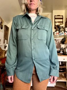 The best shade of green  Amazing 1970's Big Mac Jcpenny button up  Utility wear style button up  Super lightweight and worn in perfectly  Peaked collar  Buttons down front  Chest pockets  Button cuffs  A fairly large stain down back of shirt  Check last photos  It's a darker stain but when it's on you can barely see it but it is to be noted  Seems like one stitch on shoulder on one side has been mended so check the photo for the stitch  Polyester cotton material  Fits a small/medium  Measurement Green Snap Button Shirt For Fall, Green Button-up Shirt With Snap Buttons, Vintage Green Button-up Shirt, Vintage Workwear Tops With Buttoned Pockets, Vintage Tops With Buttoned Pockets For Work, Vintage Long Sleeve Tops With Buttoned Pockets, Retro Button-up Shirt With Pockets, Vintage Single Breasted Button-up Tops, Vintage Single-breasted Button-up Tops