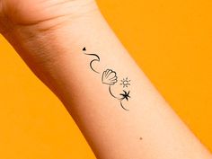 a person's arm with a small tattoo on it