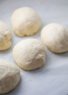 four uncooked doughnuts sitting on top of a baking sheet