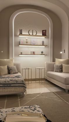 a living room with two couches, a bed and a shelf on the wall