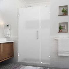 a bathroom with a sink, mirror and shower stall in the middle of the room