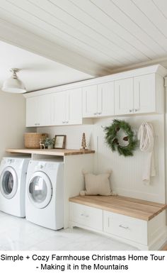 a washer and dryer in a white laundry room with christmas wreath on the wall