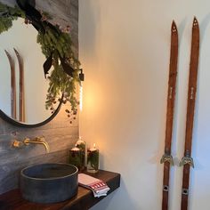 two skis are propped up against the wall in front of a sink and mirror