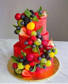 a three tiered cake decorated with fresh fruit