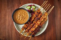 chicken skewers with dipping sauce on a plate