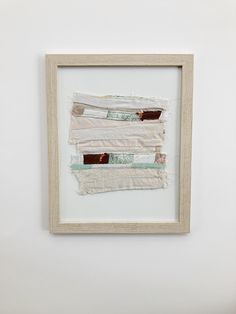 a piece of fabric is hanging on the wall next to a framed photograph with tape