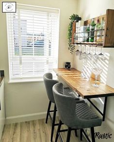 there is a table with wine glasses on it next to the bar area in this kitchen