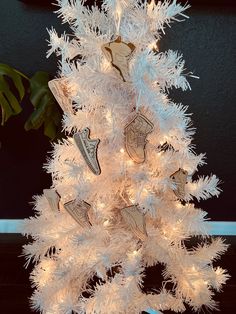 a white christmas tree with lights and decorations