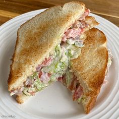 a sandwich cut in half sitting on top of a white plate