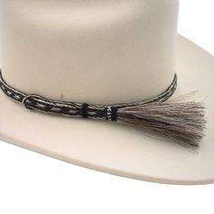 Enhance your hat with the natural elegance of the Pepper Horsehair Braided Single Tassel Hat Band. Made from 100% genuine horsehair, this beautifully crafted hat band combines durability with sophisticated style. Handmade with precision, it features a 3/8 inch width and an adjustable design to fit most hat sizes comfortably. The single tassel adds a unique touch, making this hat band a standout accessory. Please note that the hat is not included with the purchase of this hat band. Elevate your h Elegant Brown Hat Band For Ranch, Elegant Brown Hat Bands For Rodeo, Adjustable Flat Brim Hat With Fringe, Adjustable Beige Hat Bands For Formal Occasions, Elegant Flat Brim Hat Band For Country Events, Elegant Adjustable Beige Hat Bands, Adjustable Fur Felt Hat Band For Rodeo, Elegant Adjustable Rodeo Hat, Elegant Adjustable Hat For Rodeo