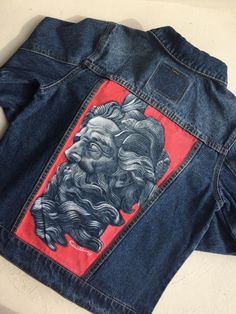 a jean jacket with an image of a man's face on it