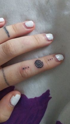 a woman's hand with some small tattoos on her left thumb and finger ring