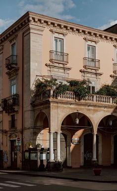 an old building with plants on the balconies