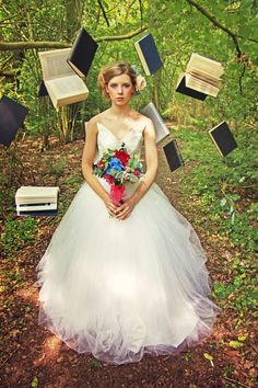 a woman in a white dress is surrounded by books