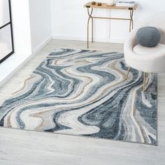 a white chair sitting on top of a wooden floor next to a blue and beige rug