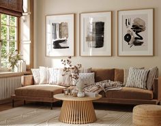 a living room filled with furniture and pictures hanging on the wall above a coffee table