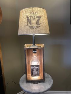 an old no 7 brandy bottle lamp on a table with a light shade over it