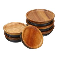 four wooden plates with black rims stacked on top of each other in front of a white background