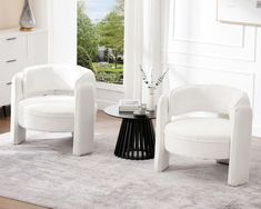 two white chairs and a table in a room