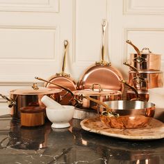 copper pots and pans on a marble table