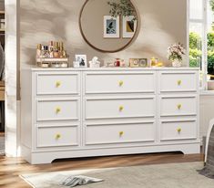 a white dresser with yellow knobs in a room