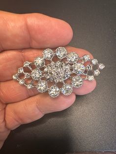 "The \"Lucille\" brooch is crafted in a Marquis design. Shaped like a diamond the Lucille brooch has a center of clustered rhinestones. Then round substantial rhinestones circle it and lastly smaller round ones peak on both sides. To be worn horizontal or vertical either way will show the brilliance of this piece. Truly flawless Lucille can we worn daily or just for those special events. Don't sleep on her she's priced for a quick exit. From Her Majesty's fine collection of jewels take Lucille h Crystal Brooches With Rhinestones For Anniversary, Elegant Round Rhinestone Brooches, Elegant Round Brooches With Rhinestones, Round Crystal Brooch For Party, Crystal Round Brooch For Party, Anniversary Rhinestone Round Brooches, Anniversary Brooches With Rhinestones, Anniversary Round Rhinestones Brooches, Anniversary Round Brooches With Rhinestones