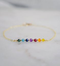 "Pride Bracelet - Rainbow Bracelet - Natural Gemstone Chakra Bracelet This bracelet can also be made with the stones in order of the Chakras. Please leave a note in the \"note to seller\" box at checkout to have it made in a Chakra style. This bracelet is handmade with an array of gemstones (listed below) in between tiny gold or silver glass beads. It is available in sterling silver or 14kt gold fill. Please measure your wrist size before purchasing. If purchasing as a gift the adjustable size of 6.5 to 7.5\" fits most average women.   GEMSTONES: - Emerald - Apatite - Lapis Lazuli - Amethyst  - Garnet - Carnelian - Yellow Cubic Zirconia MATERIALS - Faceted Gemstones (mixed shapes and sizes) - Gold or Silver Glass Beads - Clasp: 14kt Gold Filled or Sterling Silver  EXTRAS - Each bracelet is Adjustable Rainbow Gemstone Bracelet, Rainbow Bracelet Jewelry For Healing, Adjustable Rainbow Gemstone Jewelry, Adjustable Rainbow Birthstone Jewelry, Rainbow Bracelet For Jewelry Making, Pride Jewelry, Bracelet Emerald, February Birthstone Jewelry, Multicolor Bracelet