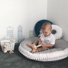 a baby is sitting on a round bed