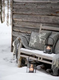 a bench sitting in the snow next to a wooden wall with a quote on it